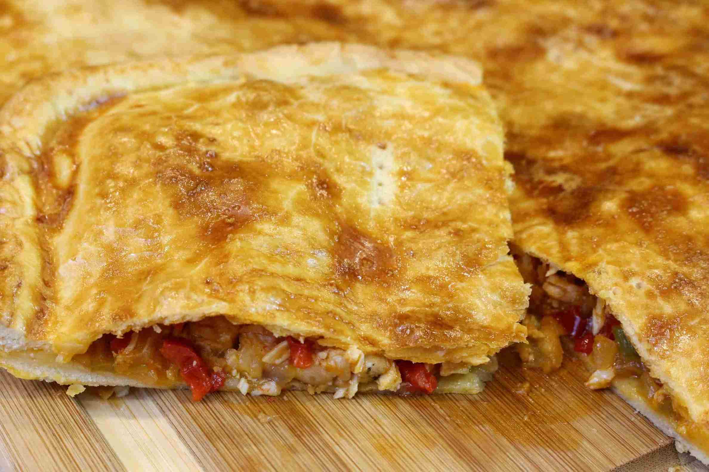 Empanada de hojaldre con pollo y verduras casera recién horneada y lista para degustar