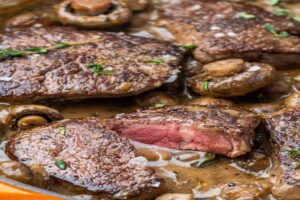 Plato de solomillo de ternera con champiñones en salsa casera al vino blanco, receta fácil y jugosa