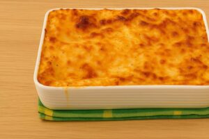Plato de macarrones caseros con carne picada, bechamel cremosa y queso dorado gratinado al horno.