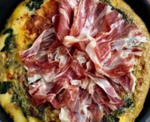 Deliciosa tortilla de espinacas con jamón y queso casera, receta fácil y jugosa, servida en un plato y lista para comer.