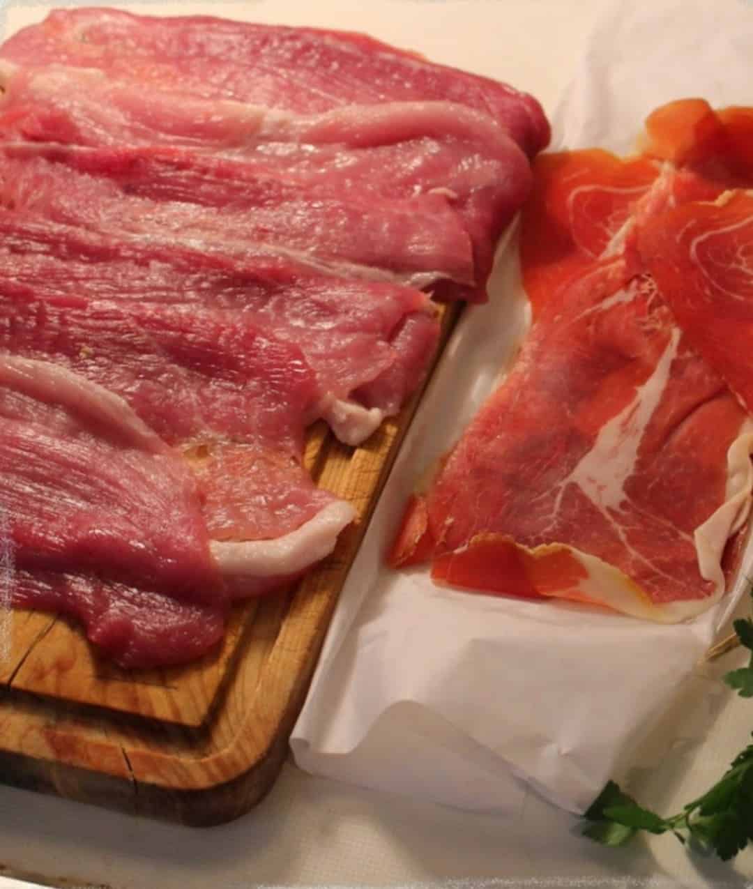Filete de lomo de cerdo extendido con lonchas de jamón serrano encima, listo para enrollar el flamenquín.