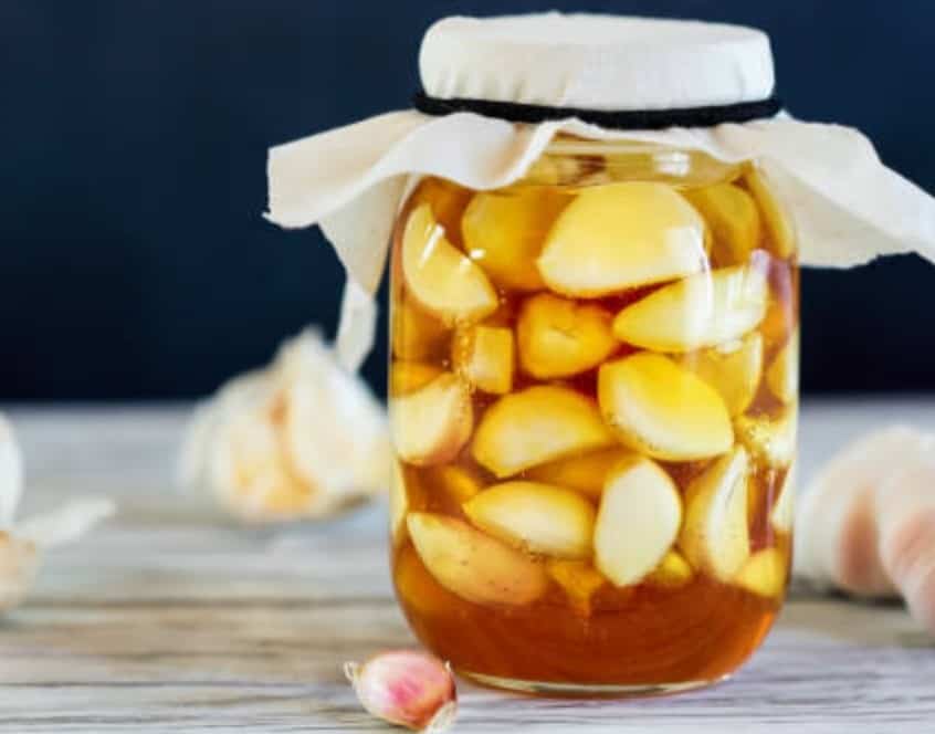 Dientes de ajo pelados conservados en un frasco de cristal con aceite.