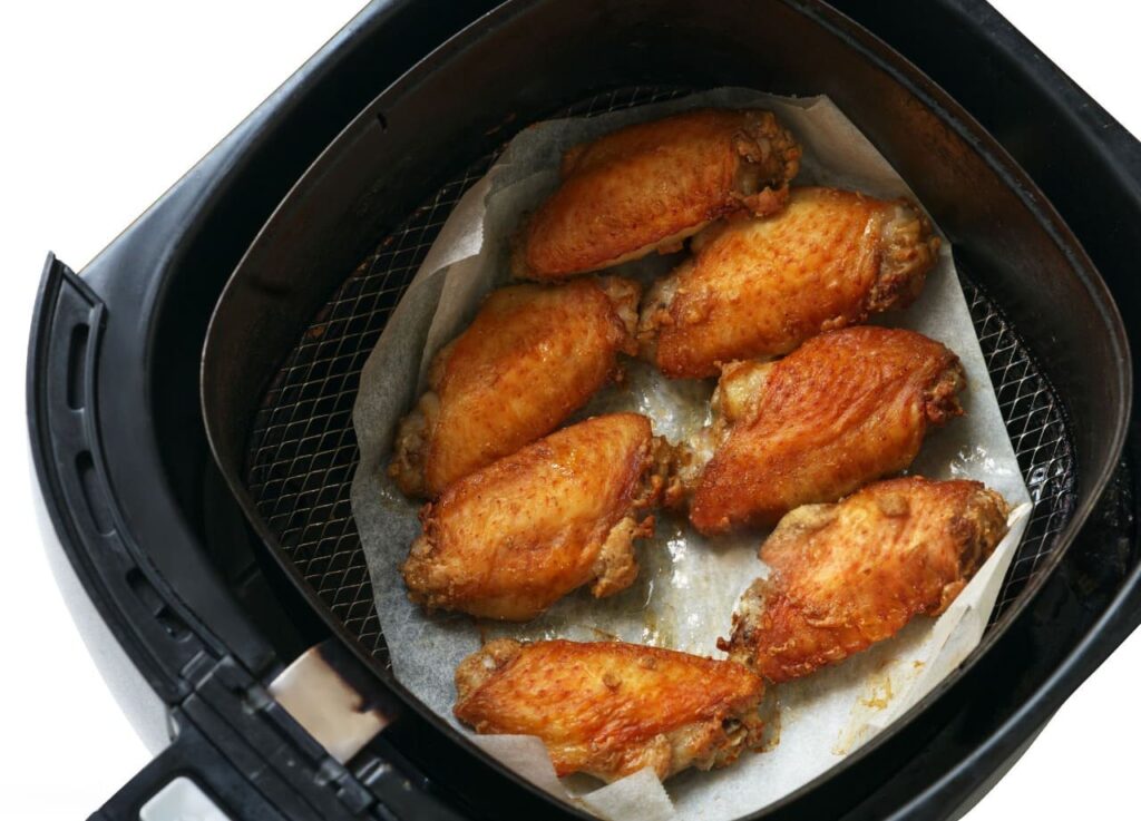 Vista de las alitas de pollo en freidora de aire crujientes y sabrosas