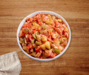 Plato de pisto andaluz tradicional siguiendo la receta de la abuela, servido en una cazuela de barro.