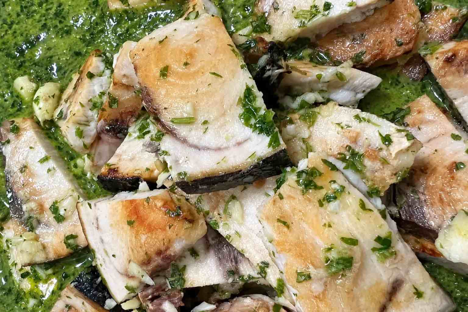 Lomos de pez espada a la plancha dorados y bañados con salsa verde espesa de perejil y ajo.