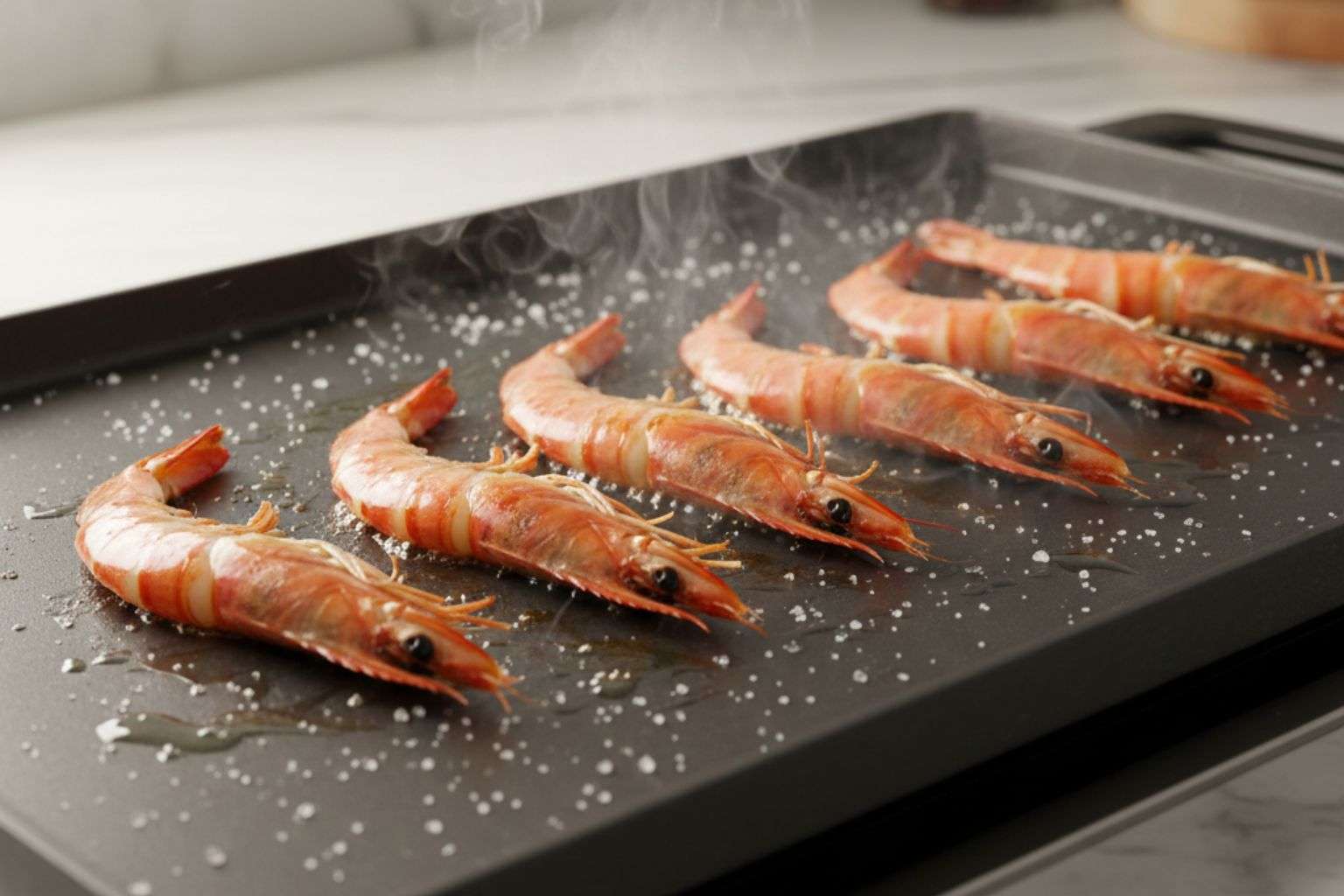 Gambones cocinándose a fuego fuerte sobre una plancha de cocina caliente.