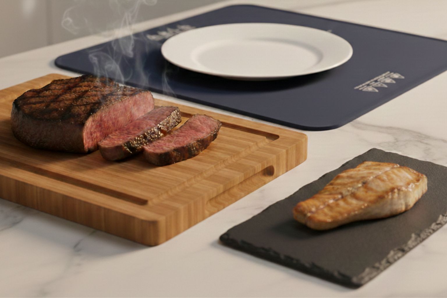 Accesorios de servicio para plancha: tabla de bambú con carne en reposo, plato tipo pizarra con pescado y placa térmica calentando plato blanco