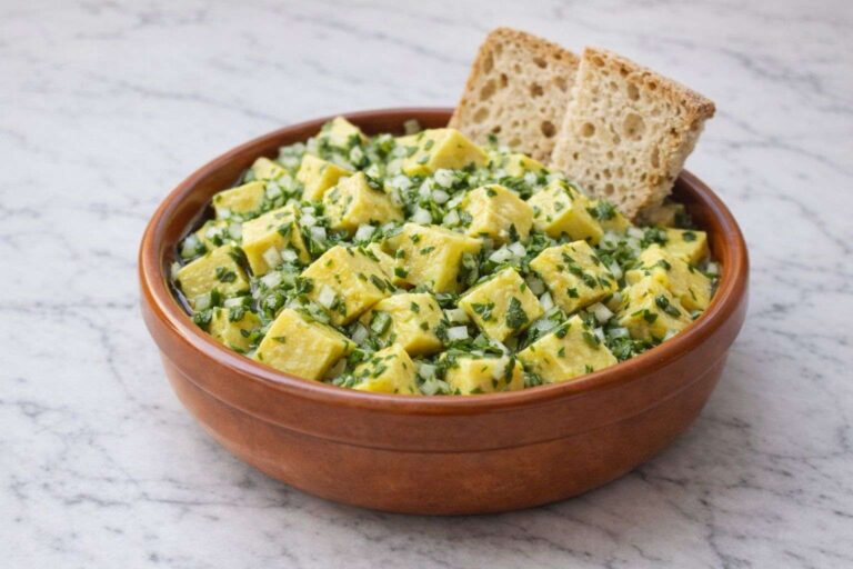 Ración de Huevos de Fraile (masa de garbanzo) aliñados con cebolleta, perejil y mucho aceite de oliva, servidos con pan.